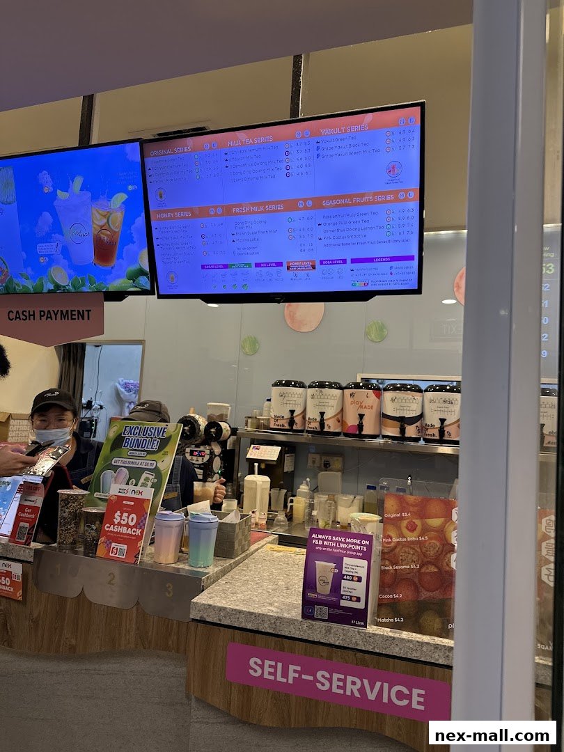 A menu board displaying various milk tea, yakult, honey, fresh milk, and seasonal fruit tea options with prices.