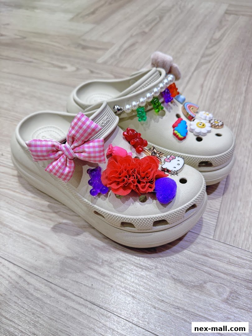 A pair of beige Crocs adorned with colorful charms, bows, and faux fur.