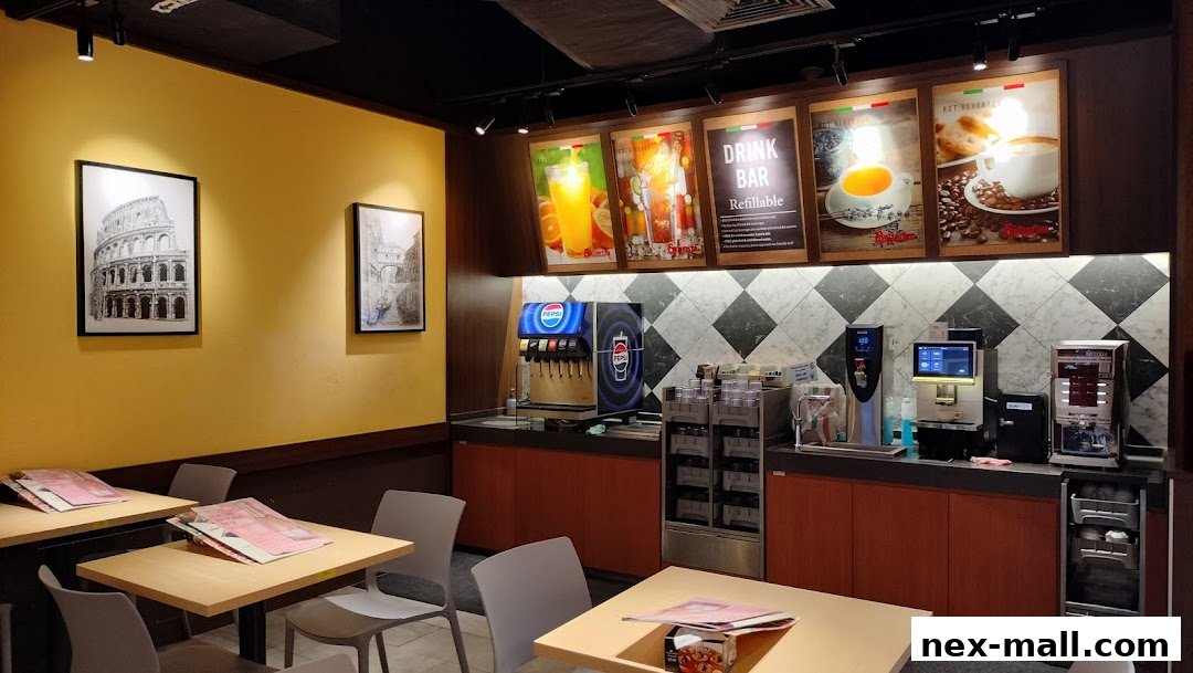 Interior of a Saizeriya restaurant with tables, chairs, and a drink bar.