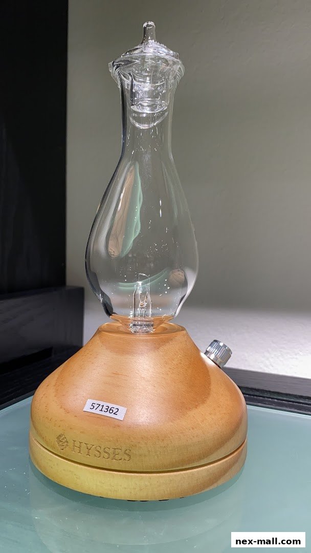 A close-up of a HYSSES diffuser with a glass top and wooden base.