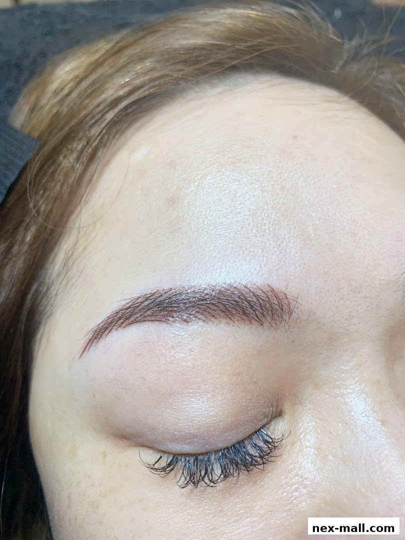 Close-up of a woman's eye with perfectly shaped and filled eyebrows and voluminous eyelashes.