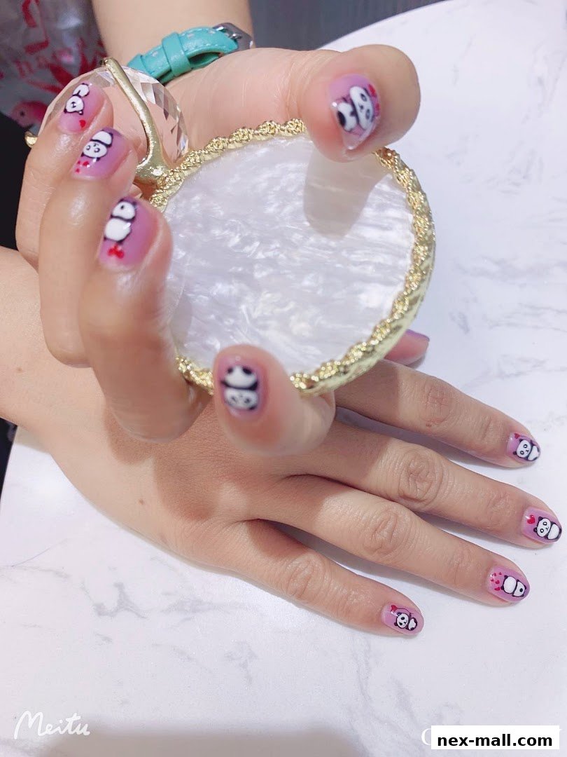 A close-up of a woman's hands with cute panda-themed nail art.