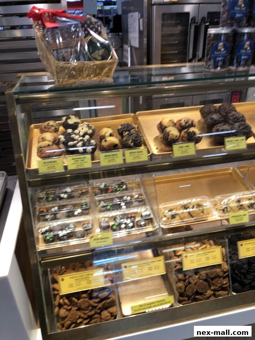 A display case filled with various cookies, muffins, and gift baskets from Famous Amos.