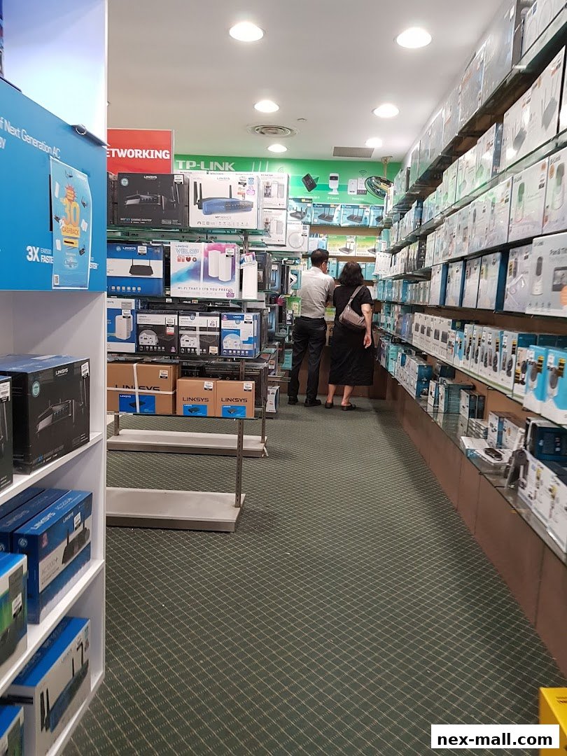 Customers browsing networking equipment and electronics in a well-stocked retail store.