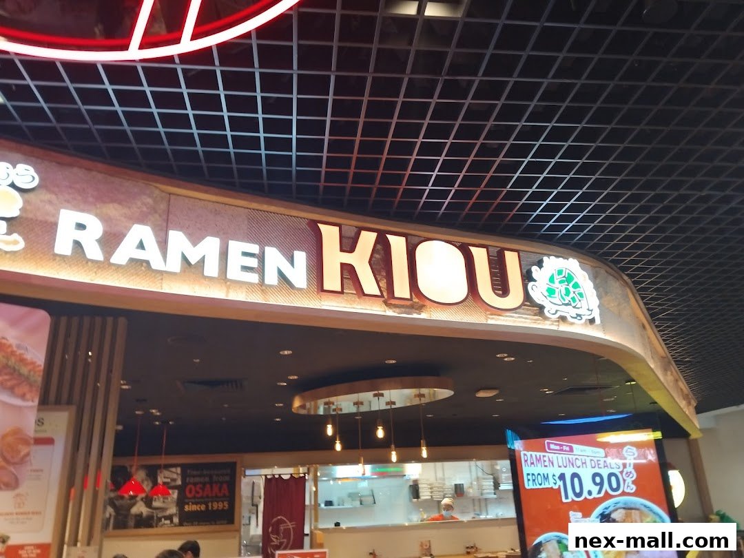 The illuminated sign for RAMEN KIOU, a ramen restaurant, with a promotional display.