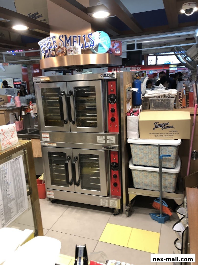 Famous Amos shop with ovens and cookie boxes, featuring a 'Free Smells' sign.