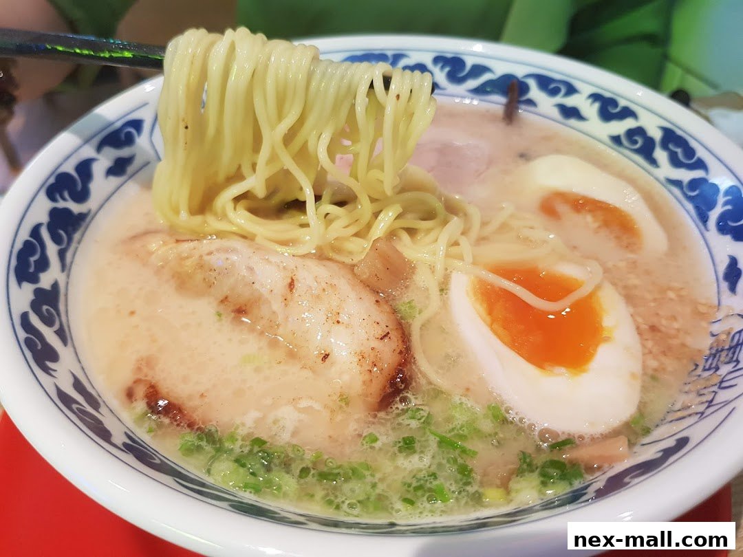 A close-up shot of a steaming bowl of ramen with noodles, pork, and a soft-boiled egg.