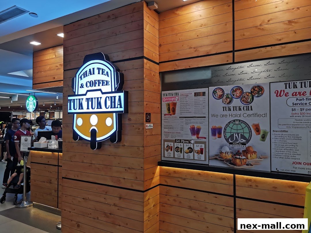 The exterior of a Tuk Tuk Cha shop with its logo and menu boards displayed.