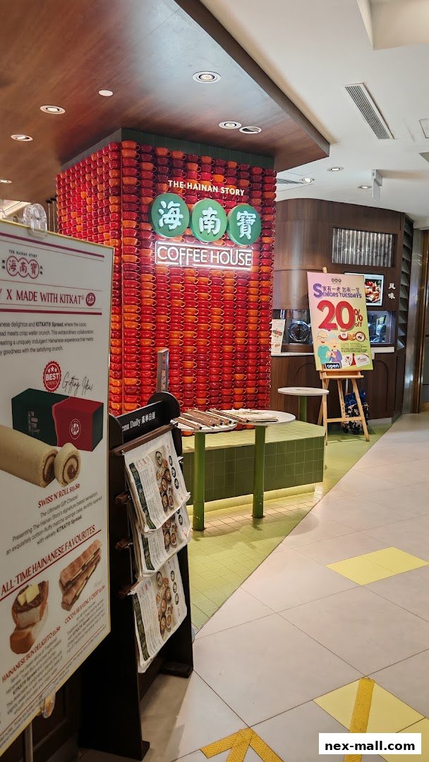 The Hainan Story Coffee House with a striking wall of stacked cups and promotional signage.