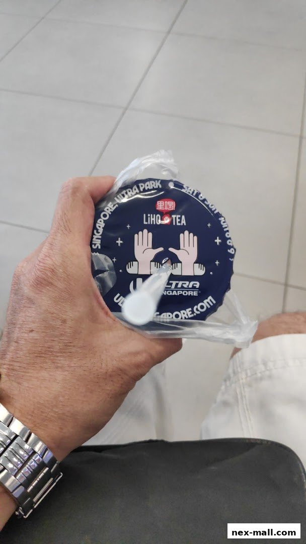 A hand holds a LiHO TEA cup with a blue lid featuring the brand logo and text.