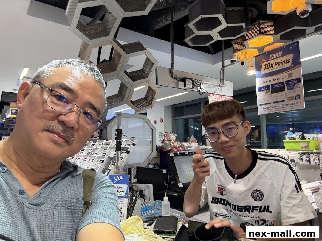 Two men are inside a mobile repair shop, with one giving a thumbs up.