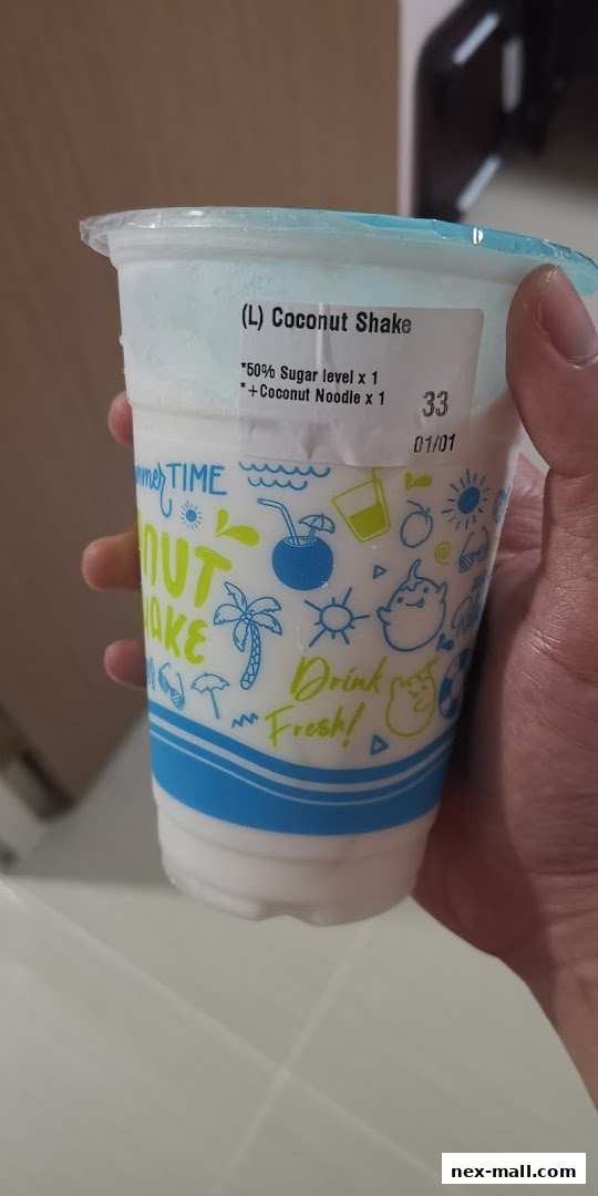 A hand holds a large coconut shake with a label indicating customization options.
