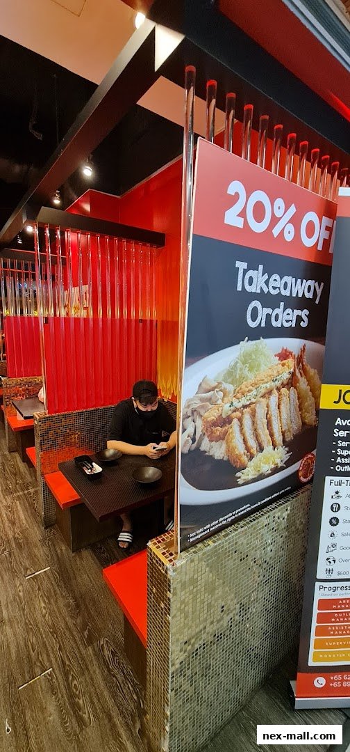 Interior of Monster Curry with a customer seated and a 20% off takeaway order promotion.