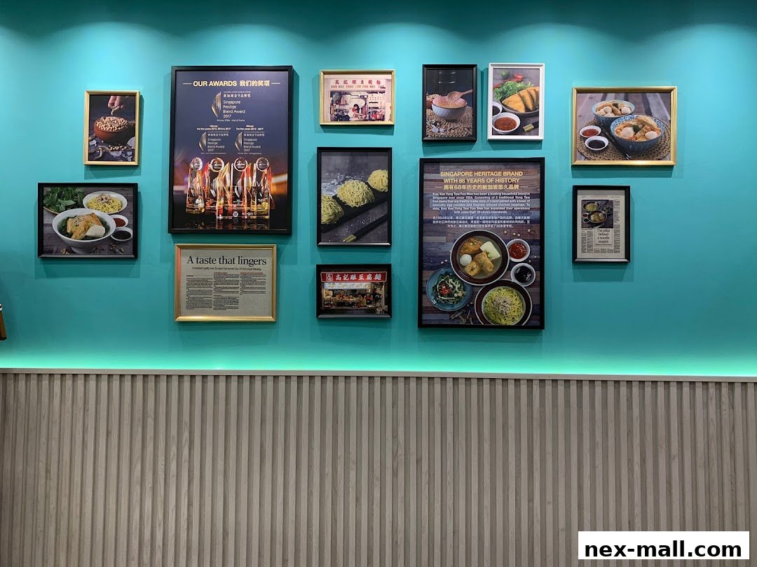 A wall decorated with framed awards, historical information, and food photos for Koo Kee.