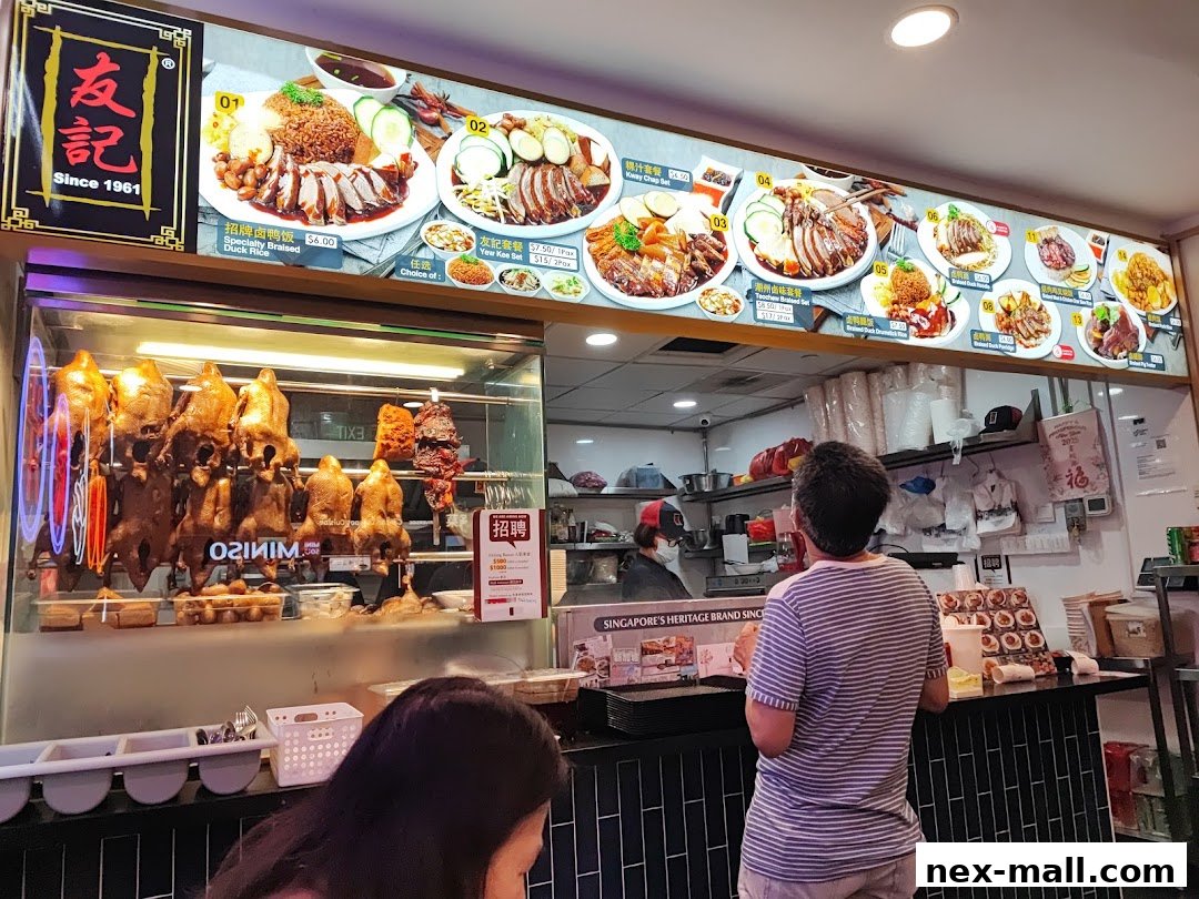 A food stall display featuring roasted ducks and various braised duck dishes with prices.