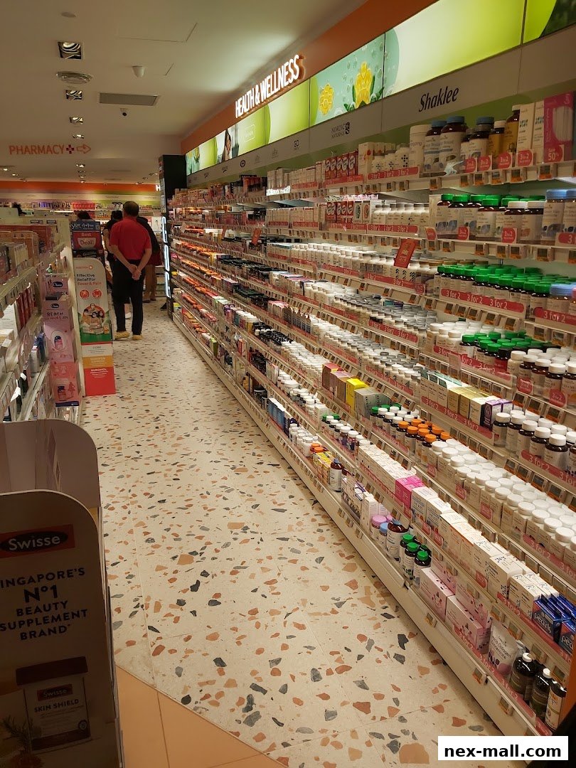 A wide aisle in a Guardian pharmacy with shelves stocked with health and wellness products.