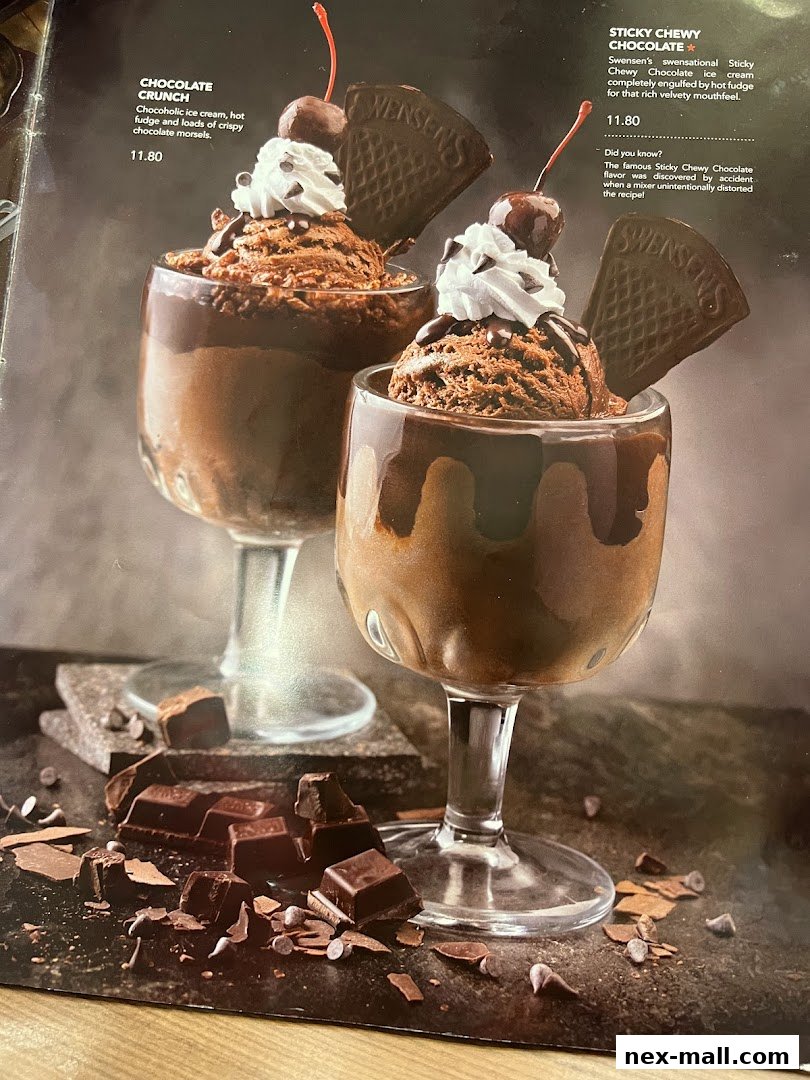 Two decadent chocolate ice cream sundaes with whipped cream, cherries, and chocolate wafers.