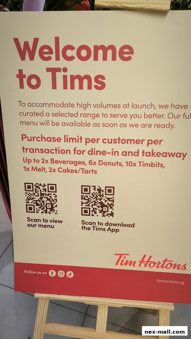 A sign welcomes visitors to Tim Hortons, directing them to scan QR codes for the menu and app.