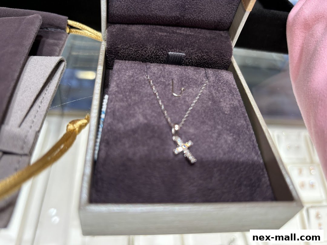 A delicate cross necklace displayed in a jewelry box.