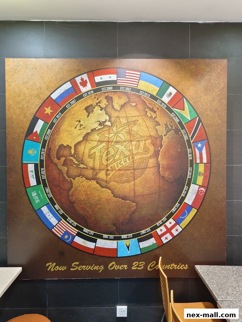 A wall mural at Texas Chicken NEX featuring a globe with flags and establishment dates.