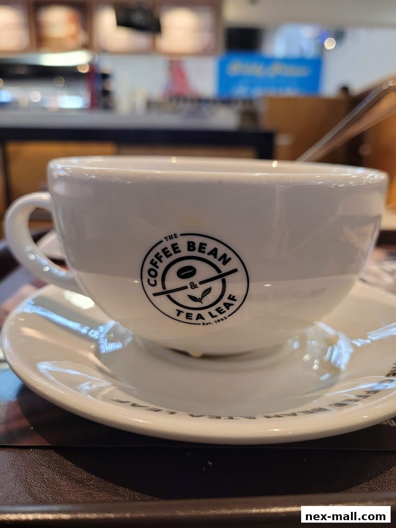 A close-up shot of a white coffee cup with the Coffee Bean & Tea Leaf logo on a saucer.