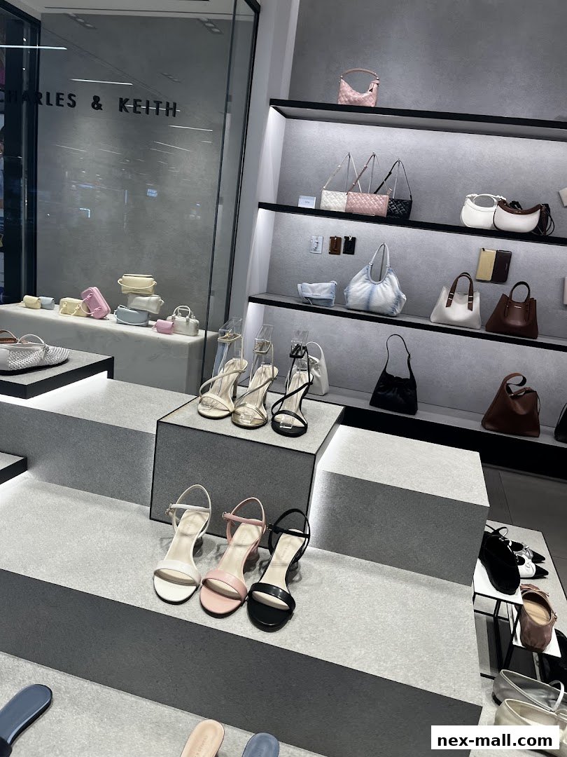 A well-lit display of Charles & Keith handbags and heeled sandals in various colors.