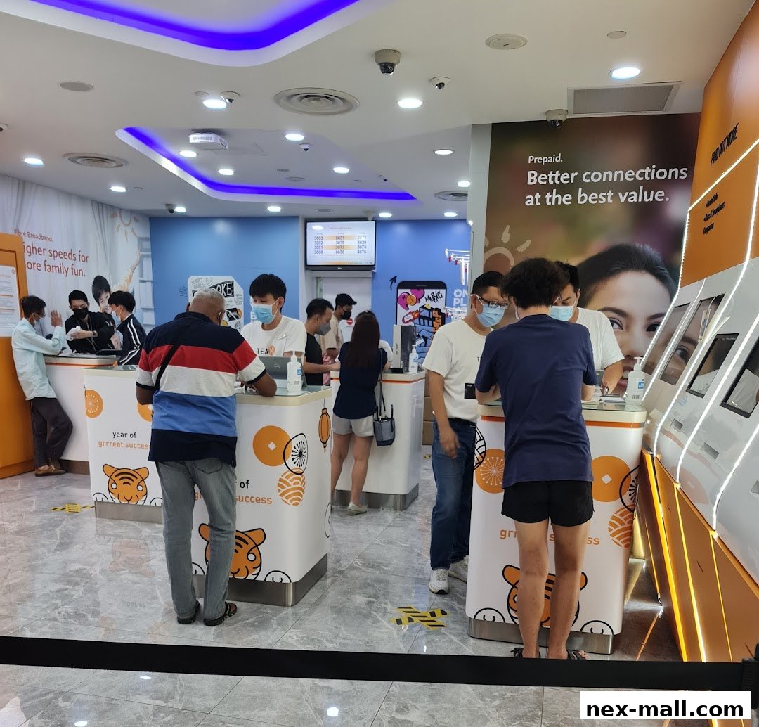 Customers are being served at counters inside a brightly lit phone shop with promotional displays.