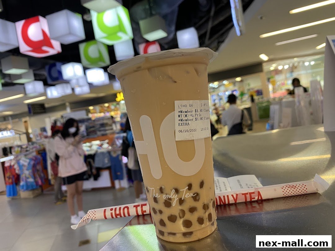 A close-up of a bubble tea drink from LiHO TEA with a receipt and straw.