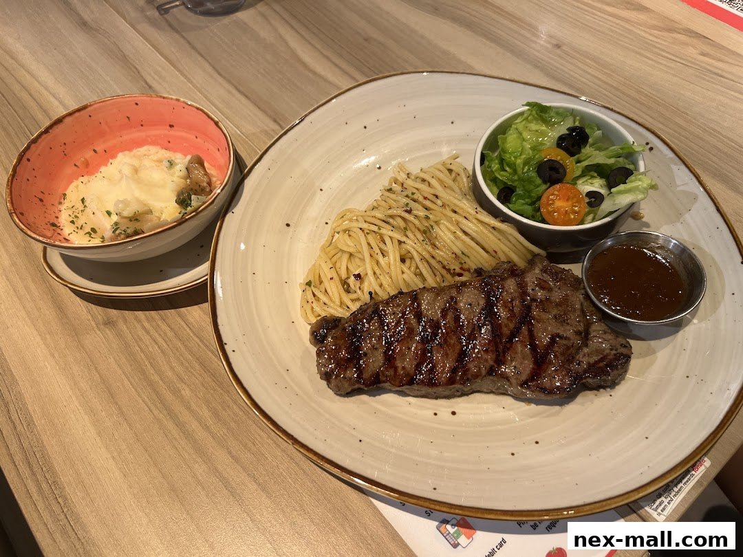 A grilled steak with spaghetti, salad, and a side dish of mashed potatoes.
