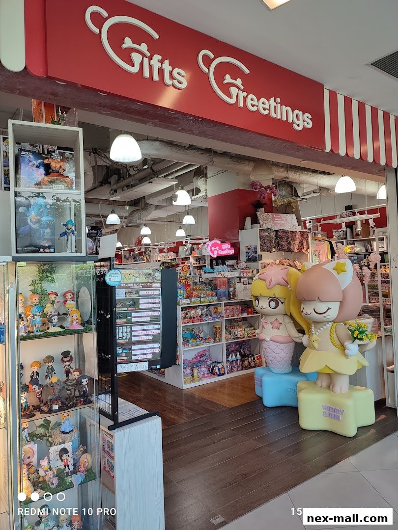 The entrance of a gift shop called Gifts Greetings, featuring anime figures and merchandise.