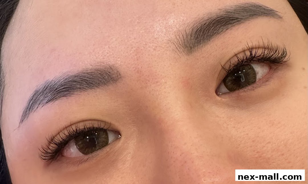 Close-up of a woman's eyes showcasing beautifully applied eyelash extensions and well-groomed eyebrows.