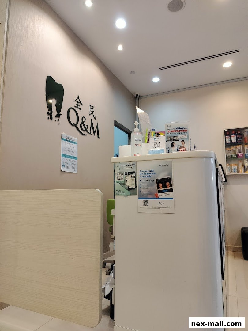 The reception area of Q&M Dental Surgery, featuring the clinic's logo and promotional posters.