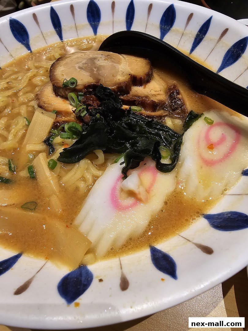 A close-up shot of a delicious bowl of ramen with pork, seaweed, and narutomaki fish cake.