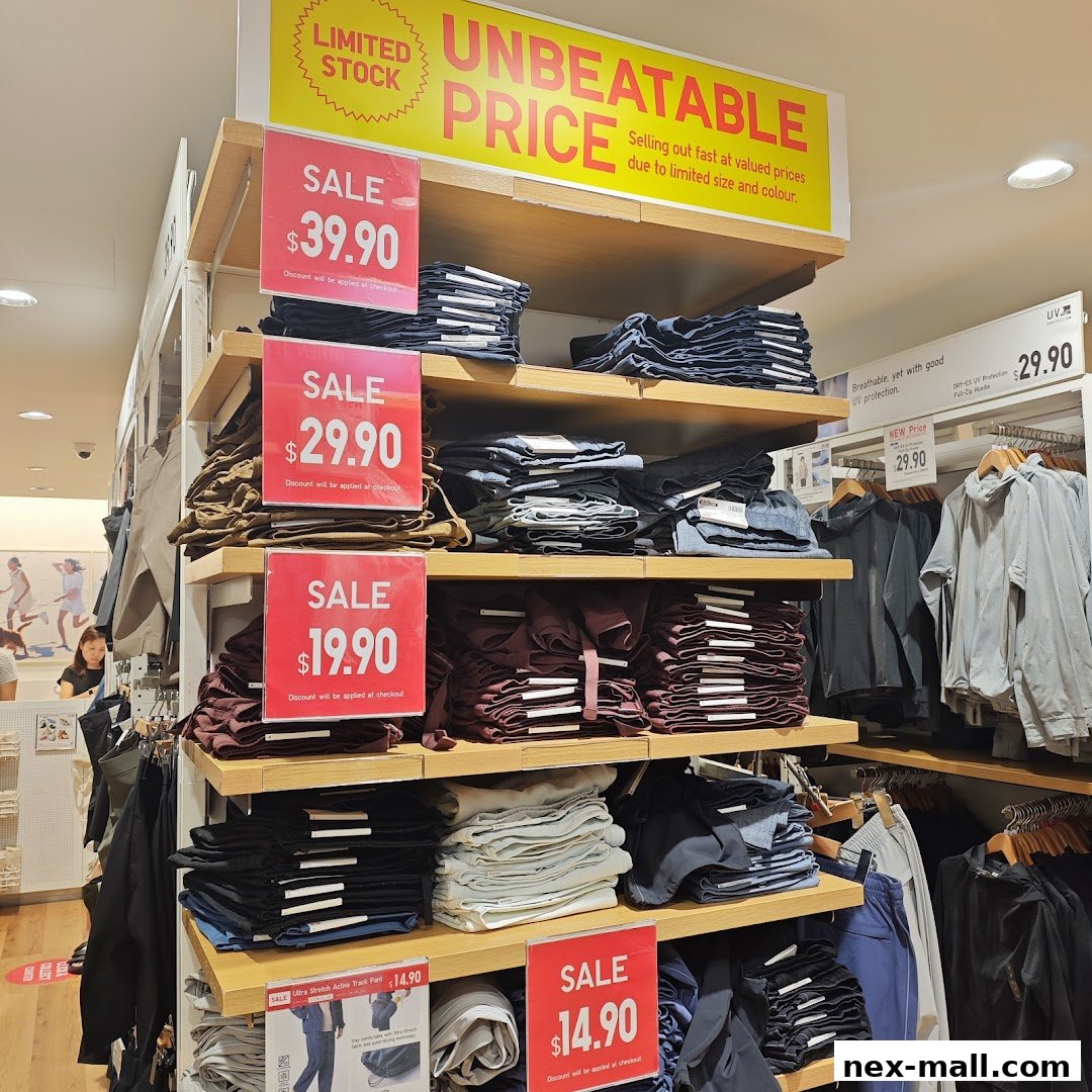 Shelves stocked with folded jeans and jackets, featuring prominent sale signs.