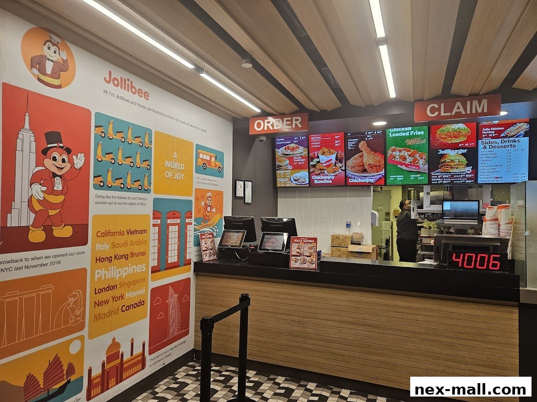 Interior view of a Jollibee restaurant with order and claim counters, and colorful wall murals.