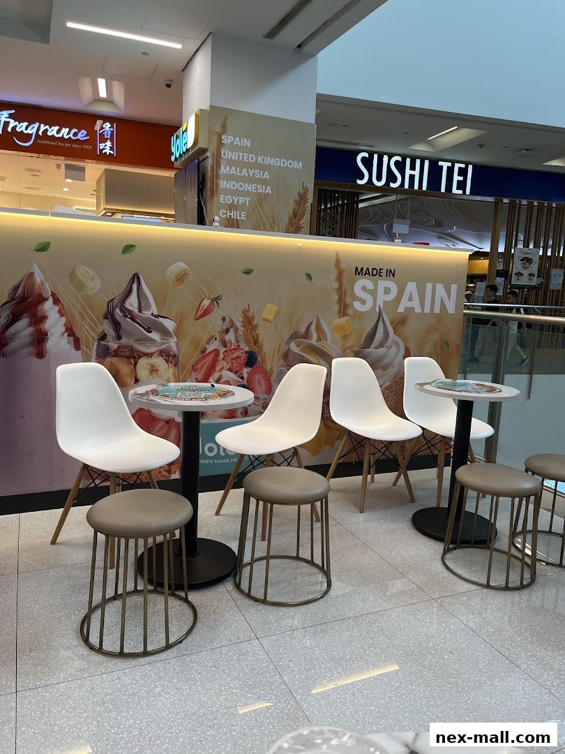 A Yolé Nex dessert shop with seating and a colorful backdrop featuring frozen desserts.
