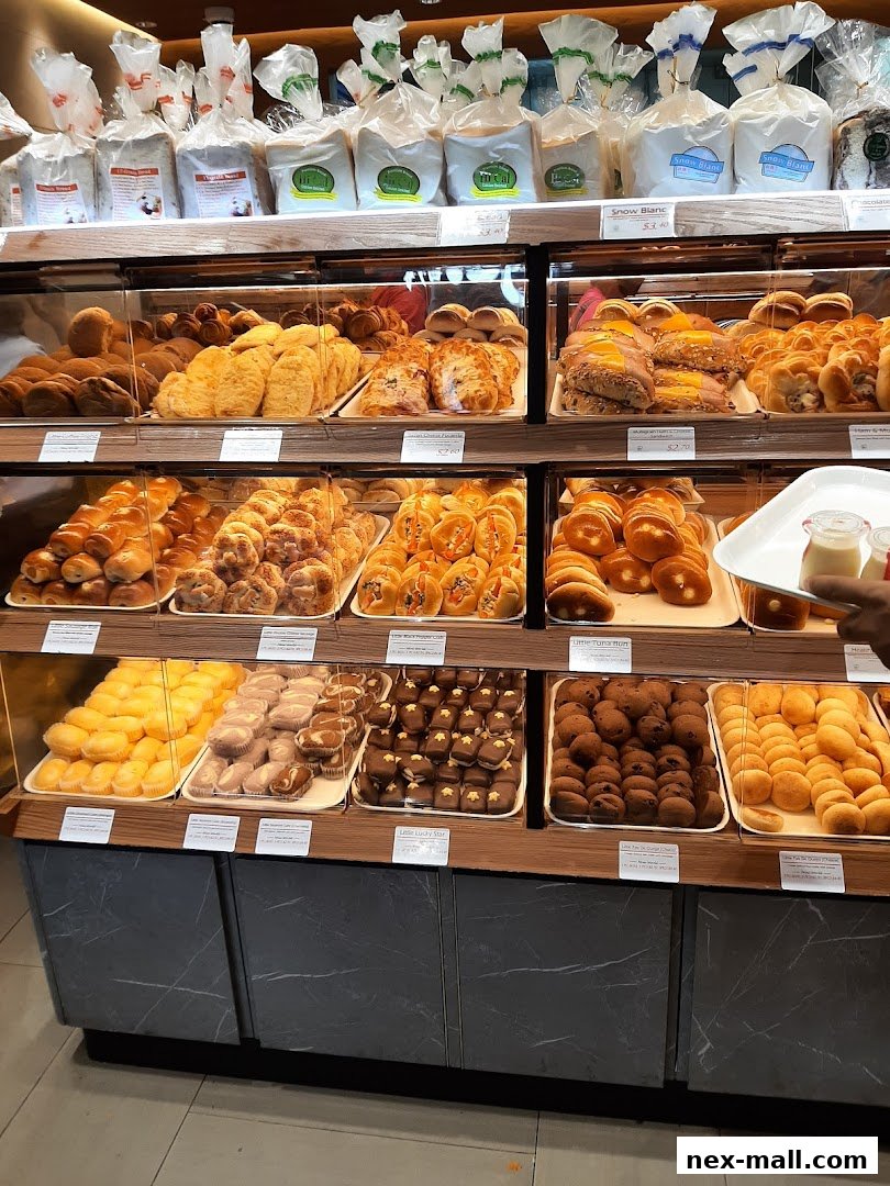 A display of freshly baked bread and pastries in a bakery, with various items neatly arranged on shelves.