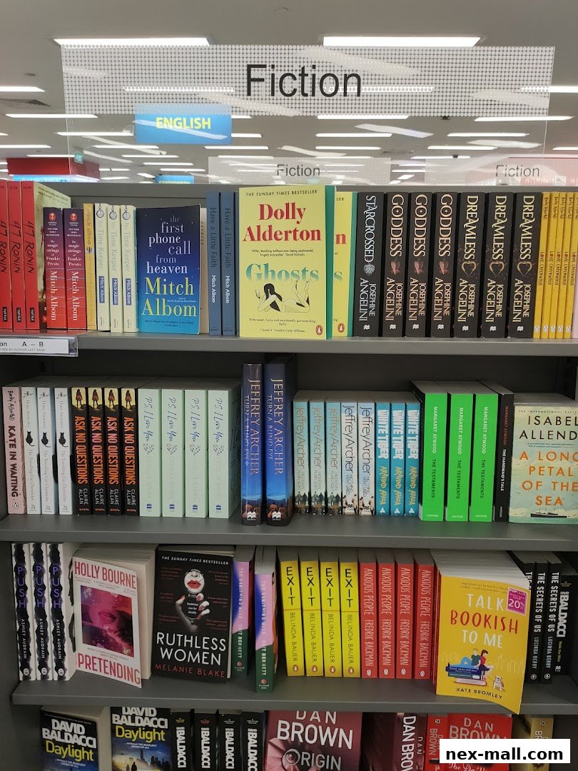 Shelves of fiction books in a bookstore, organized by author and genre.