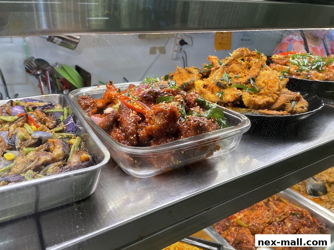 A display of various delicious Asian dishes, including fried fish, chicken wings, and stir-fried eggplant.