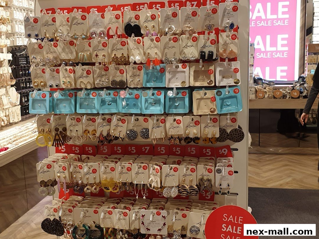 A display of various earrings and jewelry with price tags and sale signs.
