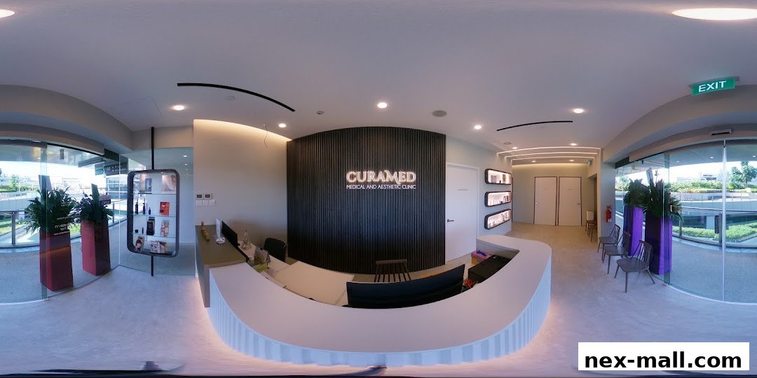 Interior view of CuraMed Medical and Aesthetic Clinic's reception area with a curved counter and branded wall.