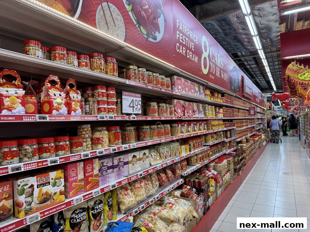 A wide aisle in a supermarket stocked with festive food items and promotions.