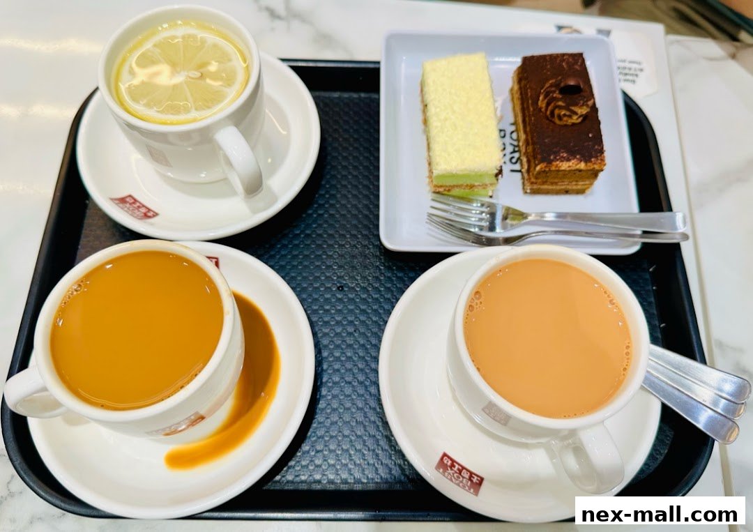 A tray with two cups of milk tea, a cup of lemon tea, and two slices of cake.