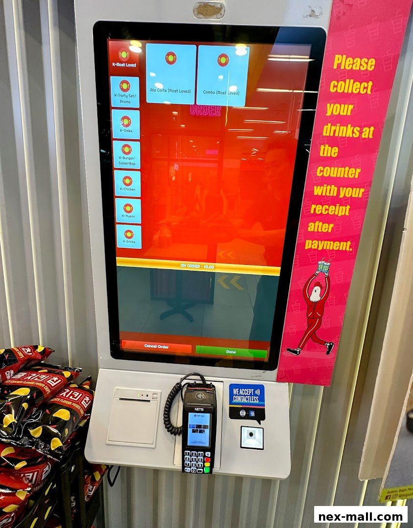 A self-order kiosk at JINJJA Chicken with menu options and payment terminal.