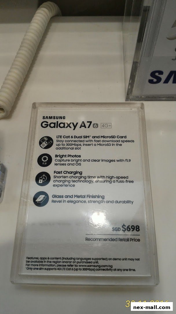 A Samsung Galaxy A7 phone with its features and price displayed on a clear stand.