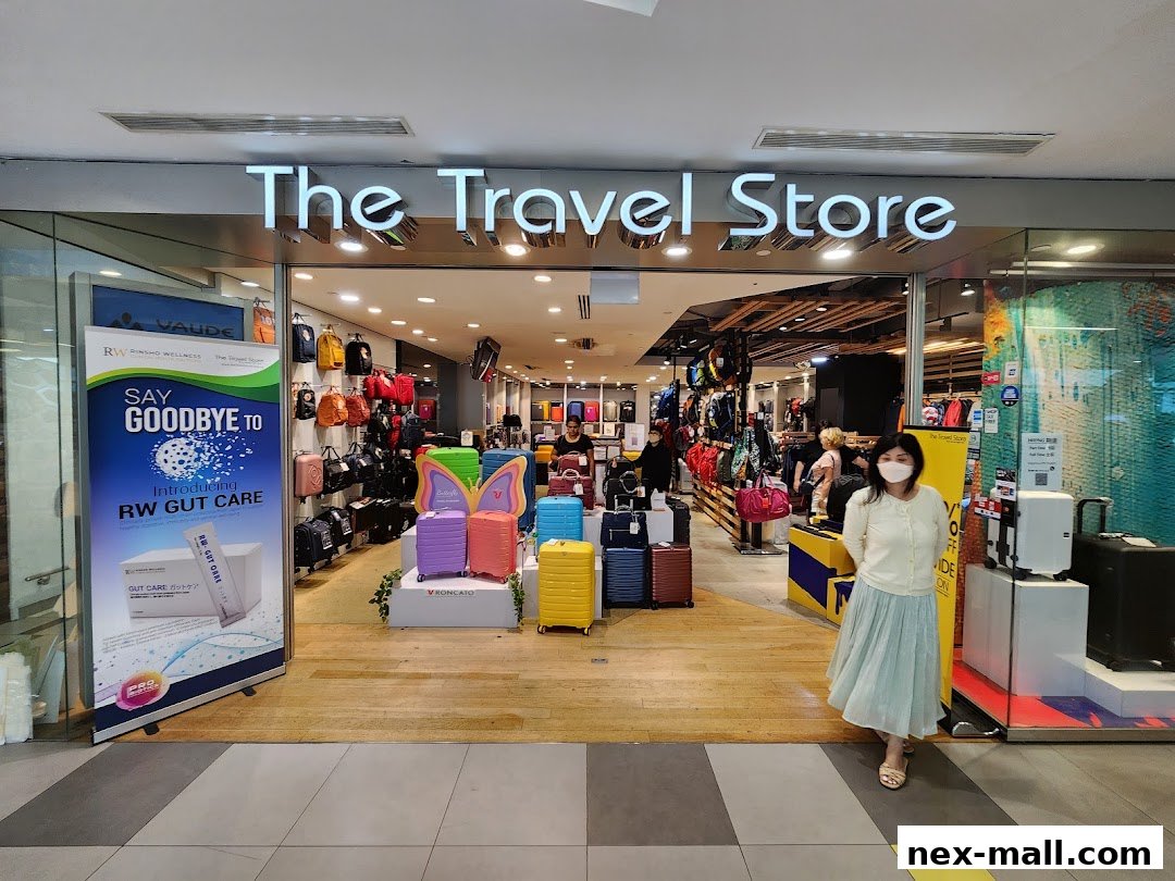 The Travel Store shop front with luggage and bags displayed, and a woman wearing a mask.