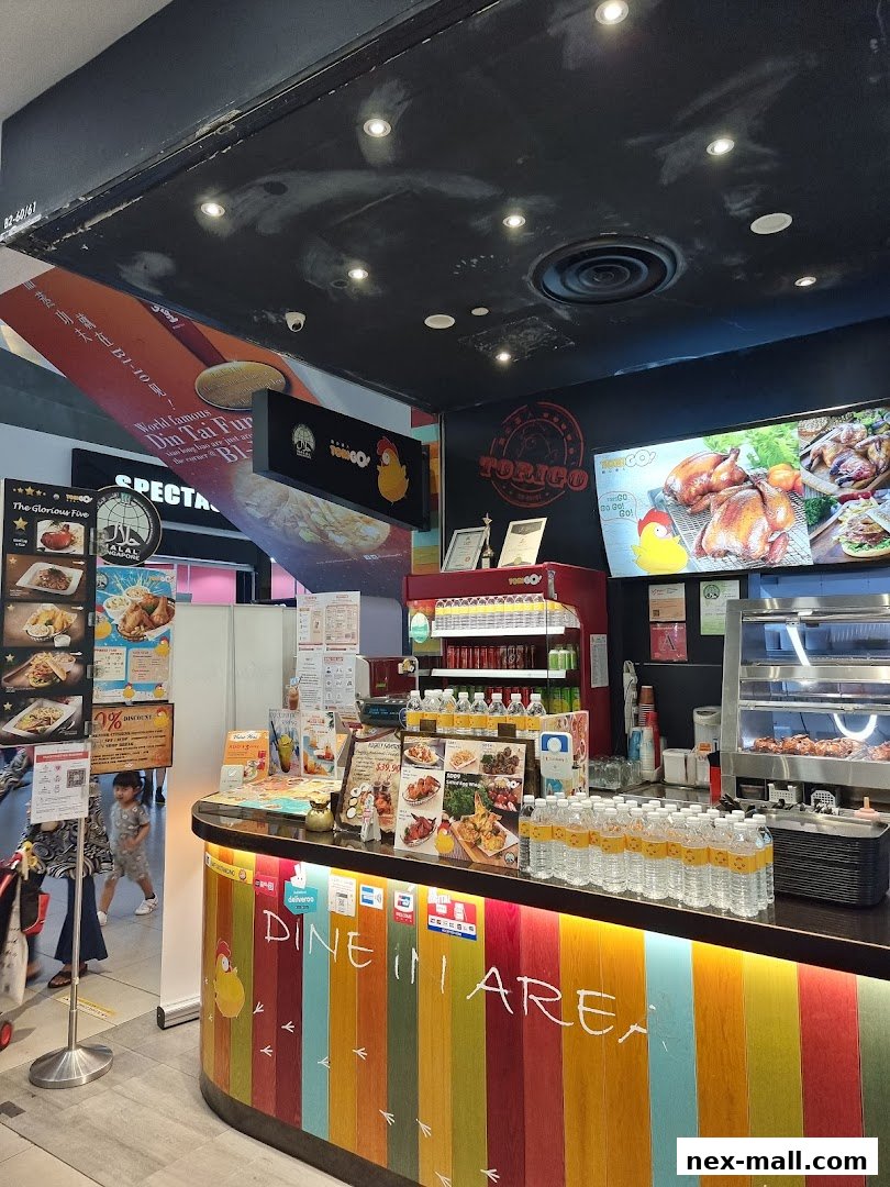 A counter at TORI-Q with roasted chickens and drinks displayed.