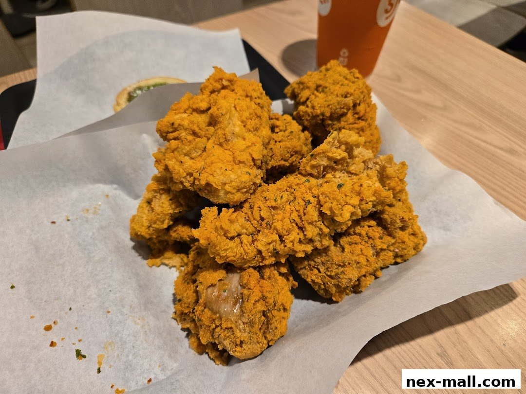 A close-up shot of crispy, golden-brown fried chicken pieces served on white paper.