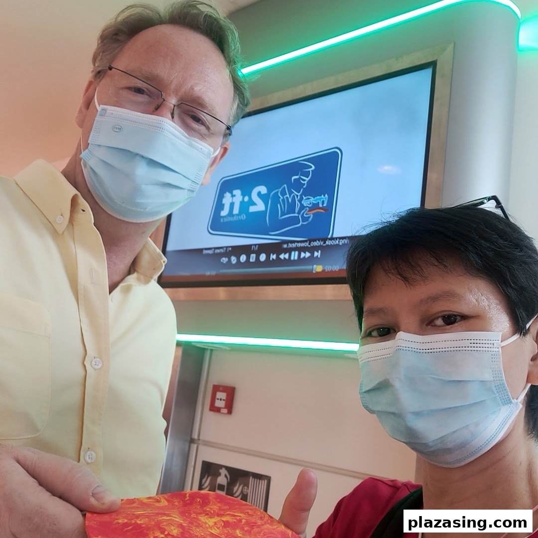 Two masked individuals inside 2ft Orthotics, with the brand's logo visible on a screen.