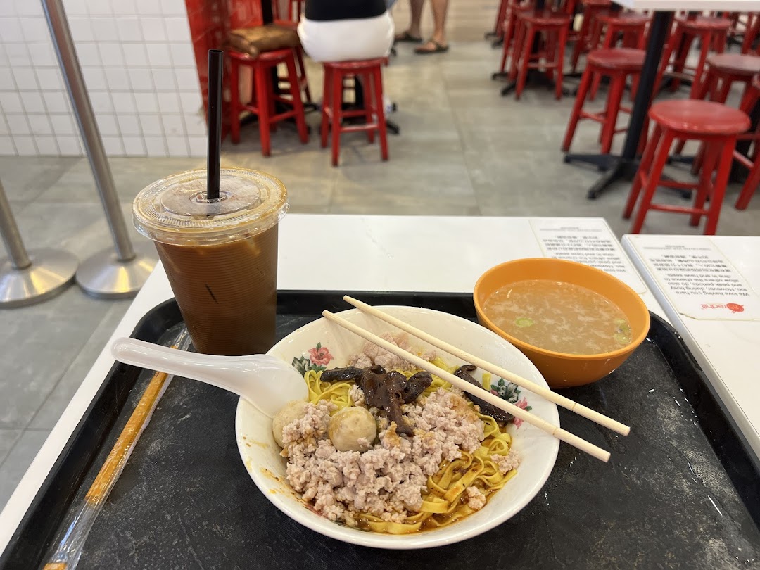 A delicious bowl of Teochew fishball noodles with minced meat, mushrooms, soup, and iced coffee.